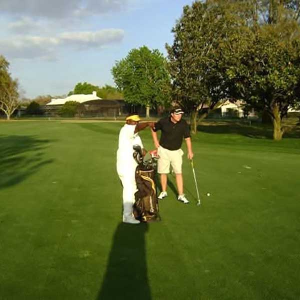 Caddie assisting golfer on course